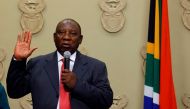 South Africa's new president Cyril Ramaphosa holds up his right hand as he is sworn into office after being elected by the Members of Parliament at the Parliament in Cape Town, on February 15, 2018. AFP/ Rodger Bosch