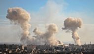 Smoke rises from buildings following bombardment on the village of Mesraba in the rebel-held besieged Eastern Ghouta region on the outskirts of the capital Damascus, on February 19, 2018. AFP / Hamza Al-Ajweh

