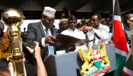 FILE PHOTO Kenyan opposition leader Raila Odinga (C) of the National Super Alliance (NASA) is assisted by lawyer Miguna Miguna (L) and James Orengo as he takes a symbolic presidential oath of office in front of his supporters in Nairobi, Kenya January 30,