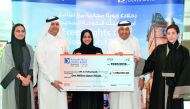 Doha Bank officials giving away a symbolic cheque for the Al Dana Saving Scheme’s QR1m  winner.
