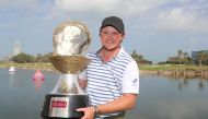 Eddie Pepperell of England poses with the winners trophy after winning the final round of the Qatar Masters golf tournament at the Doha Golf Club in Doha, on February 25, 2018. / AFP / KARIM JAAFAR
