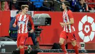 Atletico Madrid's French forward Antoine Griezmann (L) celebrates after scoring a goal during the Spanish league football match between Sevilla FC and Club Atletico de Madrid at the Ramon Sanchez Pizjuan stadium in Sevilla on February 25, 2018. / AFP / Cr