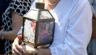 A woman holds a lantern with a picture of murdered journalist Daphne Caruana Galizia outside the law court in Valletta, Malta, on October 17, 2017.  (AFP / Matthew Mirabelli) 