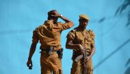 Burkinabe men patrol the army's headquarters from the roof in Ouagadougou on March 3, 2018 a day after dozens of people were killed in twin attacks on the French embassy and the country's military.   AFP / Ahmed OUOBA
