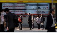 Pedestrians walk past at an electronic stock indicator showing share prices of the Tokyo Stock Exchange in Tokyo on March 6, 2018. AFP / Kazuhiro Nogi 