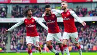 Arsenal's German defender Shkodran Mustafi (R) celebrates with Arsenal's Egyptian midfielder Mohamed Elneny (L) and Arsenal's Gabonese striker Pierre-Emerick Aubameyang (C) after scoring the opening goal of the English Premier League football match betwee