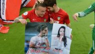 This picture taken on March 14, 2018 shows Alexandre Pato of Tianjin Quanjian (R), holding a poster showing pictures of him and Chinese actress Dilraba Dilmurat, with teammate Wang Yongpo after the AFC Champions League group stage football match between C