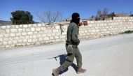 A Turkish-backed Free Syrian Army fighter holds a weapon as he walks north of Afrin, Syria March 17, 2018. REUTERS/Khalil Ashawi