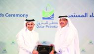 Abdulaziz Mohammed Al Mannai (left), Executive Vice-President, Human Capital, QP, honouring a staff for long service.