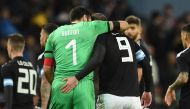 Italy's goalkeeper Gianluigi Buffon and Argentina's striker Gonzalo Higuain leave the pitch arm in arm at half time during the International friendly football match between Argentina and Italy at the Etihad stadium in Manchester, north west England on Mar
