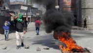 Indian Kashmiris stand along a barricaded street during unrest following gun fights between suspected militants and Indian forces in South Kashmir, in Srinagar on April 1, 2018.   AFP / HABIB NAQASH

