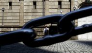 A security officer is seen through a chain link as he stands guard outside the Bank of Japan headquarters in Tokyo, March 31, 2016. Reuters / Yuya Shino