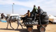 Palestinian activists collect tyres to be burnt along Israel-Gaza border, in the southern Gaza Strip April 2, 2018.  Reuters/Ibraheem Abu Mustafa
