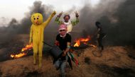 Palestinians wearing costumes are seen at the clashes scene at Israel-Gaza border in the southern Gaza Strip April 5, 2018. Reuters/Ibraheem Abu Mustafa