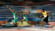 South Africa's Akani Simbine celebrates as he wins the gold medal ahead of South Africa's Henricho Bruintjies (C) and Jamaica's Yohan Blake in the athletics men's 100m final during the 2018 Gold Coast Commonwealth Games at the Carrara Stadium on the Gold