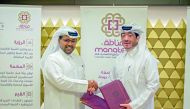 QMMF President Abdulrahman Al Mannai and Manateq’s CEO Fahad Al Kaabi pose for a photo.