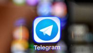 An illustration picture taken through a magnifying glass on April 17, 2018 in Moscow shows the icon of the popular messaging app Telegram on a smart phone screen. AFP / Yuri KADOBNOV