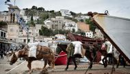 Mules transport goods from commercial ferry on the Greek island of Hydra where cars are prohibited on November 12, 2016. AFP / Louisa Gouliamaki