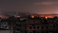 A picture taken early on April 21, 2018 shows explosions appearing in the skyline of a southern district of the Syrian capital Damascus, during regime strikes targeting the Islamic State group in the Palestinian camp of Yarmouk, and neighbouring districts