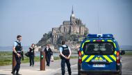 People stand on the road leading to the Mont-Saint-Michel as Gendarmes black the access after it was evacuated on April 22, 2018 of its tourists and residents 