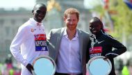 Britain's Prince Harry (C) poses with elite men's race winner Kenya's Eliud Kipchoge (L) and elite women's race winner Kenya's Vivian Cheruiyot during the trophy ceremony of the 2018 London Marathon in central London on April 22, 2018. AFP / Daniel Leal-O