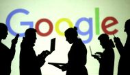 Silhouettes of laptop and mobile device users are seen next to a screen projection of Google logo in this picture illustration, March 28, 2018. (Reuters / Dado Ruvic) 