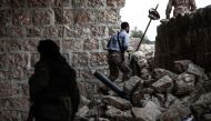 Turkish-backed Syrian fighters exit a building in Tadef, near the city of al-Bab in the northern countryside of Aleppo province on April 27, 2018. / AFP / Sameer Al-Doumy
