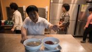 A waiter prepares to serve a 'Pyongyang naengmyeon' a cold noodle dish at the Nampo Myeonok noodle bar restaurant in Seoul on April 28, 2018. AFP / Ed JONES