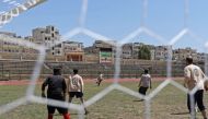 A player of the team of the Syrian Civil Defence (known as the White Helmets) kicks the ball during the first football game at Idlib's stadium since three years, in Idlib on April 25, 2018.   AFP / OMAR HAJ KADOUR
