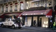 A man covers a cafe's windows with wooden boards on May 5, 2018 in central Paris as a Police removes parked cars on the way of a demonstration later today called to protest against French president's politics. AFP / Olivier Morin 