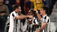 Juventus' forward Paulo Dybala from Argentina celebrates with teammate Juventus' midfielder Douglas Costa from Brazil (C) and Juventus' defender Andrea Barzagli (L) after scoring a goal during the Italian Serie A football match between Juventus and Bologn