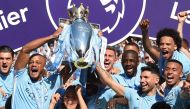 Manchester City's captian, Belgian defender Vincent Kompany (2nd L) and Manchester City's Argentinian striker Sergio Aguero lift up the Premier League trophy on the pitch after the English Premier League football match between Manchester City and Huddersf