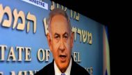 A picture taken in Jerusalem of a with TV screen shows Israeli Prime Minister Benjamin Netanyahu delivering a televised speech after the US President announced his decision to withdraw from the Iranian nuclear deal, on May 8, 2018.  AFP / Thomas Coex