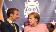 France's President Emmanuel Macron and German Chancellor Angela Merkel confer at the end of the Charlemagne prize award ceremony on May 10, 2018 in Aachen, western Germany.   AFP / LUDOVIC MARIN
