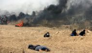 A wounded Palestinian is pictured on the ground during clashes with Israeli forces along the border with the Gaza strip, east of Gaza City, on May 11, 2018, as Palestinians demonstrate for the right to return to their historic homelands in what is now Isr