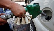 A worker fills diesel in a car as he holds 500 Indian rupee banknotes at a fuel station in Kolkata, India, November 9, 2016. (Reuters / Rupak De Chowdhuri) 
