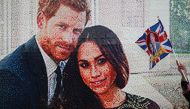 A girl waves a flag next to a LEGO brick mosaic of Britain's Prince Harry and Meghan Markle in Windsor, Britain May 18, 2018. REUTERS/Marko Djurica