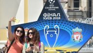 Girls make selfie in front of the official logo set on the Independence Square in the Ukrainian capital of Kiev on May 22, 2018, ahead of 2018 UEFA Champions League Final football match between Real Madrid and Liverpool FC next May 26 at the Olimpiyskiy S