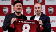 Spain midfielder Andres Iniesta and Hiroshi Mikitani, Chairman and CEO of Rakuten Inc and the owner of Vissel Kobe, pose with Iniesta's new team jersey at a news conference to announce signing for J-League side Vissel Kobe in Tokyo, Japan May 24, 2018. RE