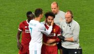 Liverpool's Egyptian forward Mohamed Salah (C) is comforted by team members and Real Madrid's Portuguese forward Cristiano Ronaldo (2nd L) as he leaves the pitch after injury during the UEFA Champions League final football match between Liverpool and Real