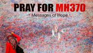 FILE PHOTO: A woman leaves a message of support and hope for the passengers of the missing Malaysia Airlines MH370 in central Kuala Lumpur March 16, 2014. REUTERS/Damir Sagolj/File Photo