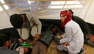 Palestinian nurse Razan al-Najjar helps an injured at an emergency medical tent during protests at the Israel-Gaza border. (Facebook/ The Palestinian Information Center) 