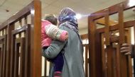 This file photo taken on February 19, 2018, shows Melina Boughedir carriyng her son, arriving in court in the Iraqi capital Baghdad. Melina Boughedir was arrested in former Islamic State group stronghold Mosul with her four children, three of whom have be
