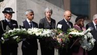 Mayor of London Sadiq Khan, (2L), Britain's Prime Minister Theresa May, (C) and Britain's Home Secretary Sajid Javid (2R) hold floral tributes during a commemoration service on the first anniversary of the London Bridge terror attack, at Southwark Needle 