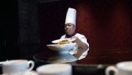 This picture taken on May 17, 2018 shows Ken Chan, the executive chef at the five-star hotel restaurant Le Palais in Taipei, displaying two dishes during an interview with AFP in Taipei. AFP / SAM YEH 