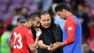 Tunisia's head coach Nabil Maaloul (C) distributes dates to Tunisia's midfielder Naim Sliti (L) and Tunisia's defender Rami Bedoui during the friendly football match between Tunisia and Turkey at the Stade de Geneve stadium in Geneva on June 1, 2018.  AFP