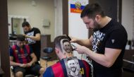 Serbian hairdresser Mario Hvala creates a hair tattoo showing the portrait of Argentinian football player Lionel Messi on the head of a football fan in Novi Sad, Serbia, on June 10, 2018. AFP / Vladimir Zivojinovic