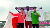 Qatar’s Muhand Saifeldin (B), winner of two gold medals  in 1,500m and 3,000m steeplechase celebrates on the podium.  