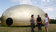 Visitors walk past a giant tent shaped like a gold loaf of bread found in the house of ex-president Viktor Yanukovich after he fled Ukraine in 2014, at the 'Corruption Park' in Kiev, Ukraine June 14, 2018. REUTERS/Valentyn Ogirenko