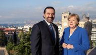 A handout picture provided by the Lebanese photo agency Dalati and Nohra on June 21, 2018 shows Lebanese Prime Minister Saad Hariri (C) and German Chancellor Angela Merkel (R) posing for a picture from a panoramic view overlooking the capital Beirut.